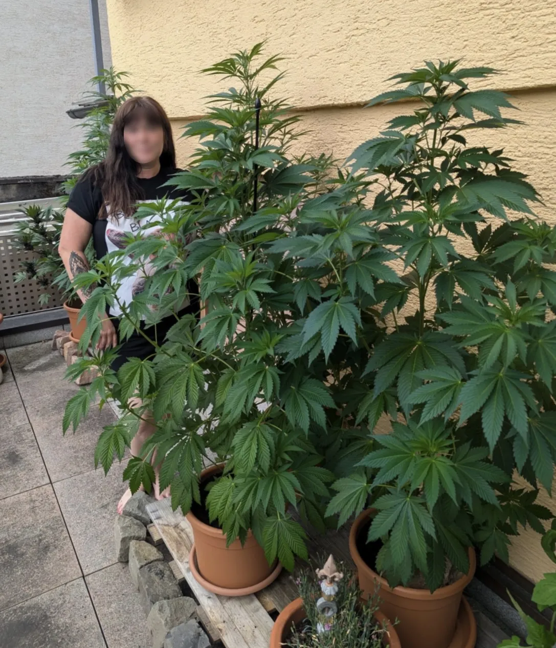 Kundin im eigenen Garten mit kräftig gewachsenen Pflanzen